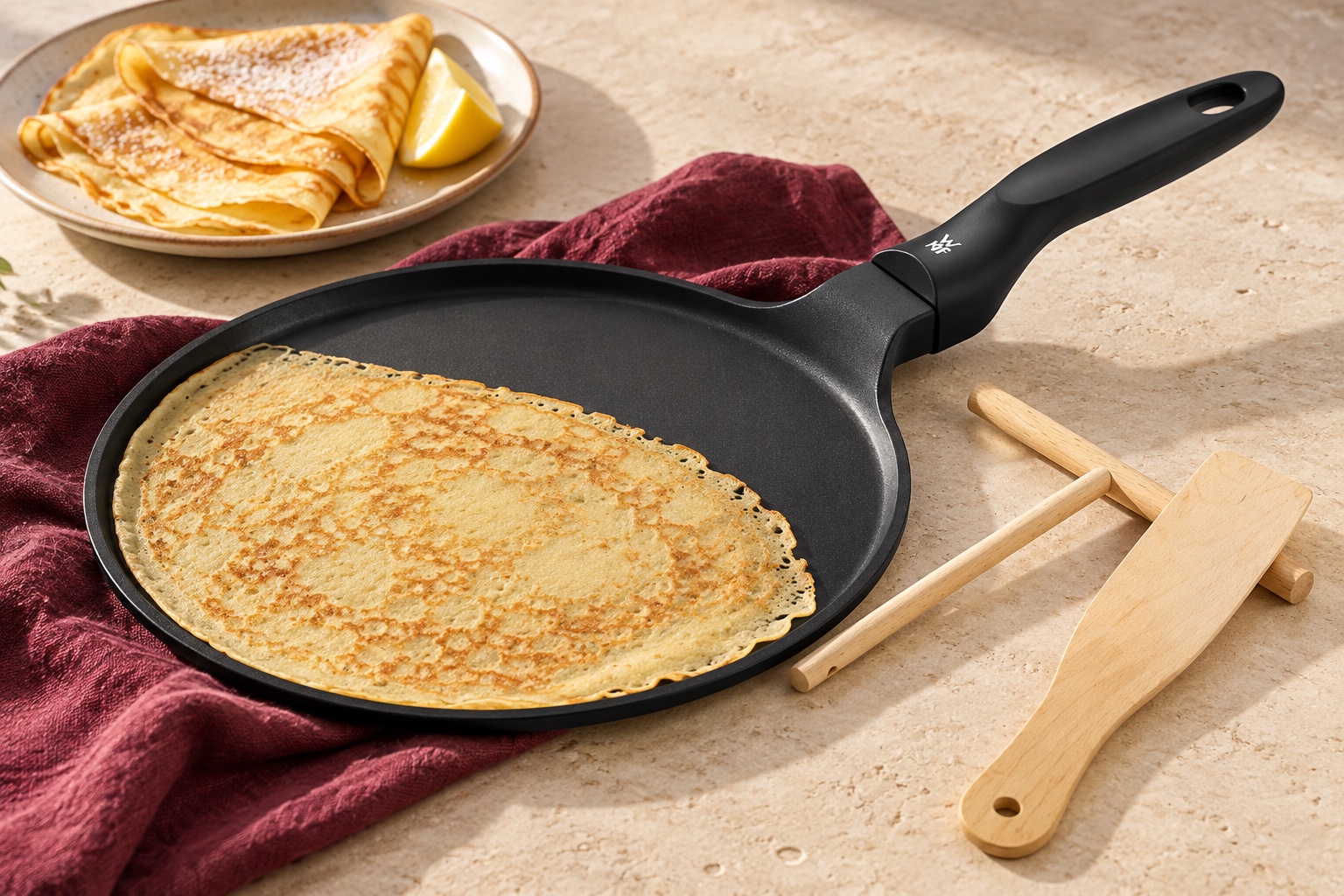 Crepera negra WMF con un crepe y sus dos accesorios de madera